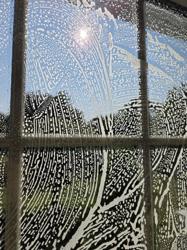 Window being cleaned with soap and cleaning solution